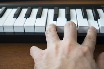 Hand Playing Notes on an Electronic Keyboard