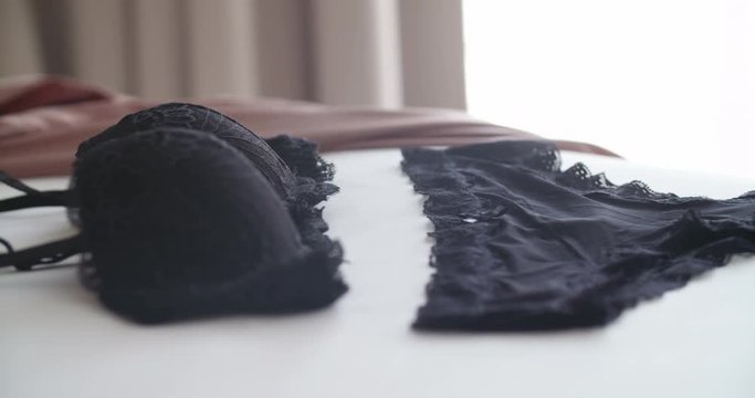 G String and bra draped on bed. close up shot