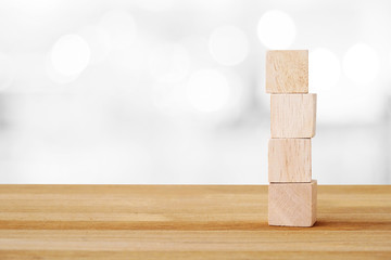 Four wooden cubes on table and blur bokeh background