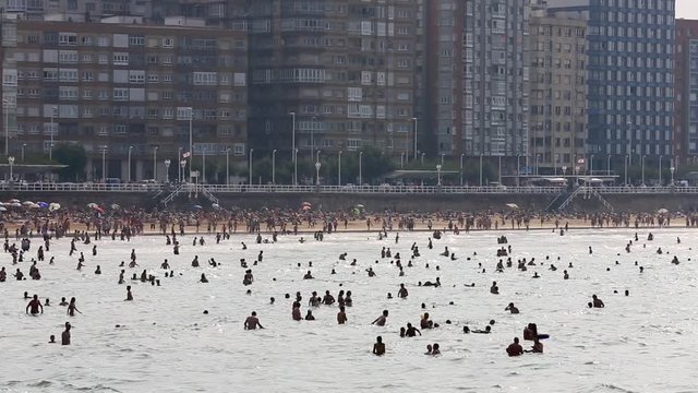Time lapse of people relaxing on crowded beach at Gijon, north Spain 