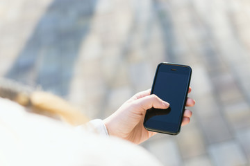 girl with smartphone outdoors in park. Closeup of female hands a