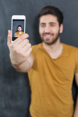 young handsome bearded hipster man selfie in the city