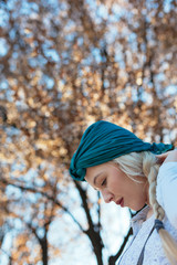 Portrait of beautiful woman in blooming tree in spring