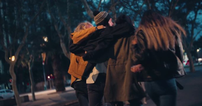 Young happy couples embracing while taking a night walk outside