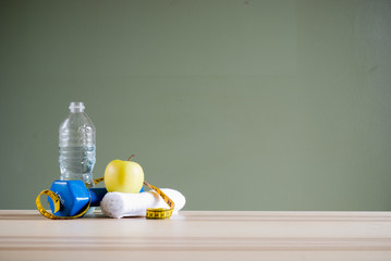 dumbbell and apple on desk
