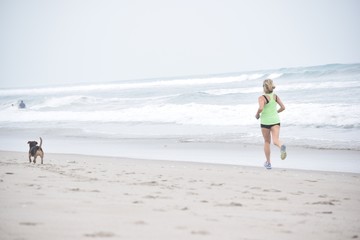 Woman Taking a Jog on Beach with Dog