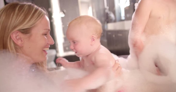 Mom, Dad and Infant Daughter Taking a Bubble Bath Together