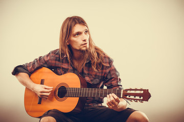 Sitting man playing guitar.