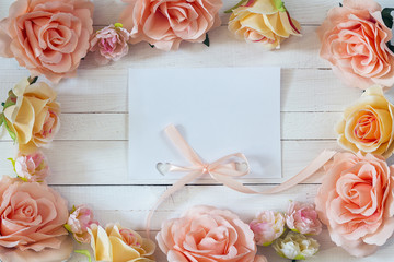 White blank card with a pink ribbon and rose flowers on white  p