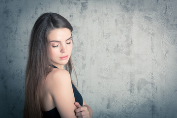 beautiful girl posing in a black evening dress. toned portrait in the studio
