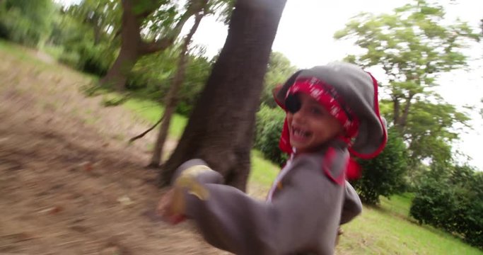 Boy dressed up as pirate with toothy smile in nature