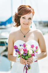 portrait of happy red-haired bride with a bouquet in hand