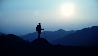 Hiker with backpack standing on the hill