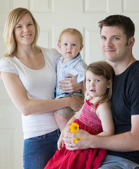Young happy, smiling family, parents with two young children, boy and girl 