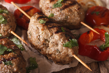 Homemade Kofta kebab with grilled vegetables on a table macro. Horizontal
