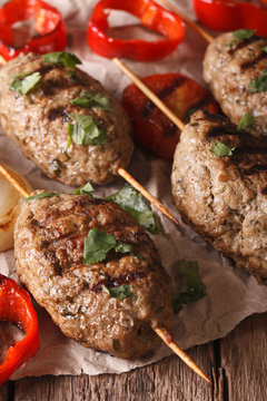 Homemade Kofta kebab with grilled vegetables on a table macro. Vertical
