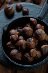 Closeup of roasted chestnuts in a frying pan, selective focus
