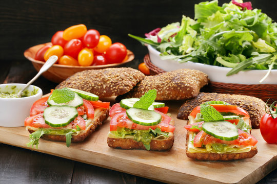 Vegetarian sandwich with pesto on wooden background