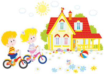 Obraz na płótnie Canvas A little girl and a little boy riding bikes on a sunny summer day near a country house