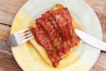 Crispy bacon on white toast, closeup
