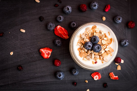 Healthy breakfast - yogurt with blueberries and muesli served in bank