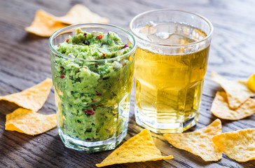 Guacamole with tortilla chips and glass of beer