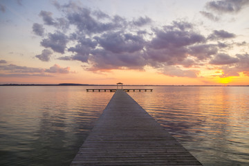 Obraz na płótnie Canvas Pomost na jeziorze po zachodzie słońca