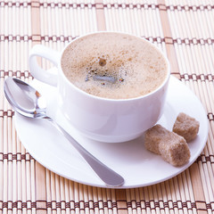 Cup of coffee, sweets and cane sugar cubes, square. Coffee concept. Selective focus.