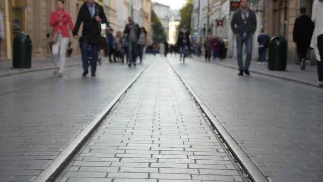 Peaople walking on the old pavement with old railroad. Timelaps
