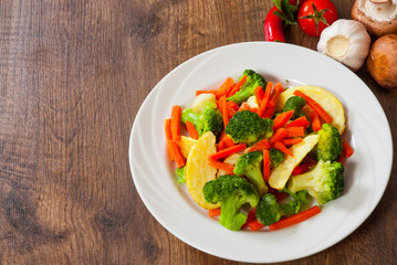 Mixed vegetables on a plate on wooden table