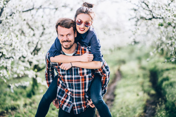 Loving couple/ Loving couple enjoying in nature. Portrait of happy young couple piggybacking and looking at the camera. 