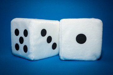 Pair of white plush dices on the blue background