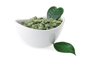 White bowl with green coffee beans on the white