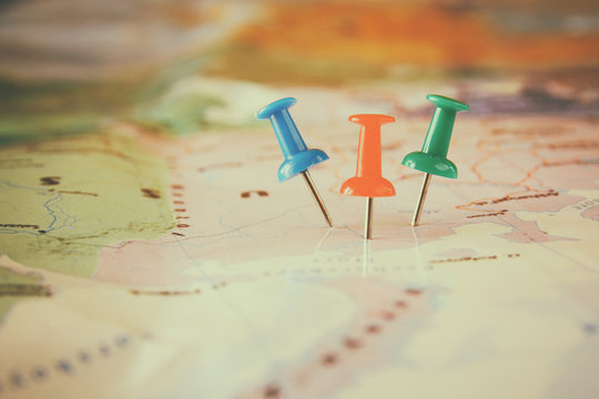pins attached to map, showing location or travel destination . retro style image. selective focus.
