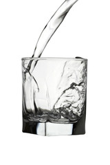 Water pouring into transparent glass isolated on white