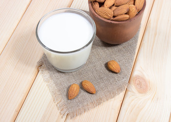 Almond milk with almond on a wooden table.
