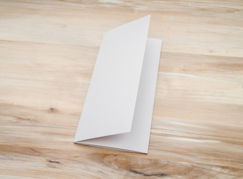 Trifold white template paper on wood texture..