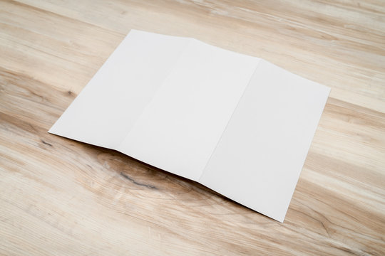 Trifold white template paper on wood texture..