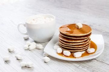 Delicious pancakes on a white background, wooden background, maple syrup, Cup of coffee