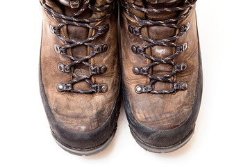 Old scuffed hiking boots isolated on white background