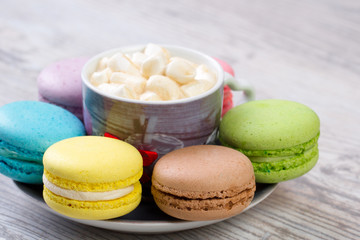 collection of colorful French macarons are next to each other around the plates
