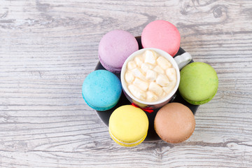 collection of colorful French macarons are next to each other around the plates
