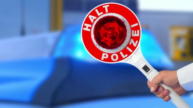 Anhaltestab vor Blaulicht am Einsatzfahrzeug der Polizei