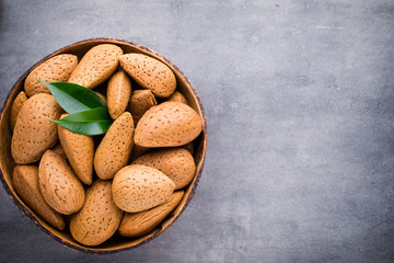 Group of almond nuts with leaves.Wooden background.