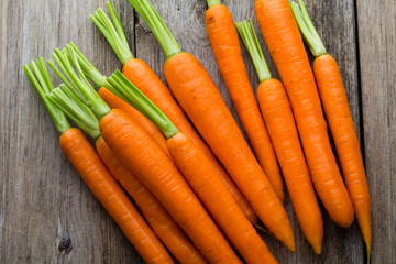 Fresh carrots bunch on rustic wooden background.