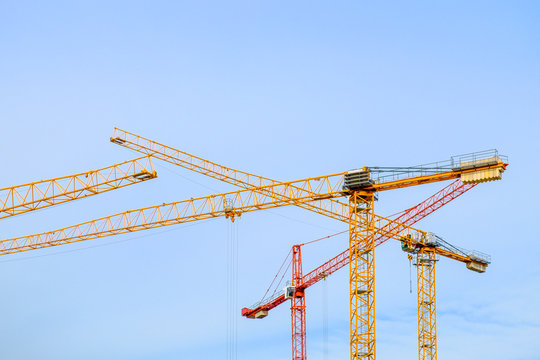Industrial image of construction cranes with sky background