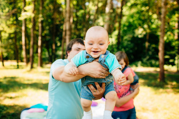 Fototapeta premium Young father with baby having fun outdoors at picnic in the park.