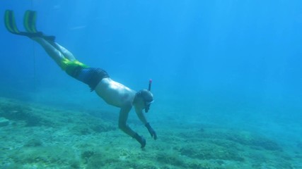 Underwater shot how diver approach to giant red starfish lying on the seabed in the natural environment.
