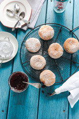 Filling homemade donuts with strawberry jam