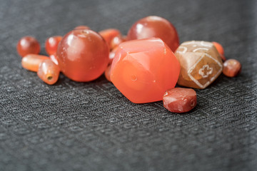 Varieties of ancient carnelian beads on Thai silk background